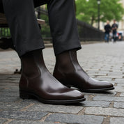 Men's Black Leather Chelsea Boots - model-sitting-bench