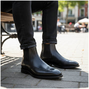model-sitting-bench - Men's Black Leather Wingtip Chelsea Boots