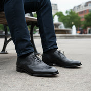 model-sitting-bench - Men's Black Ostrich Leather Wingtip Shoes