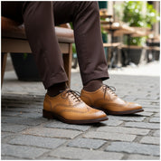 Men's Wingtip Brogue Leather Dress Shoes in Tan - model-sitting-bench